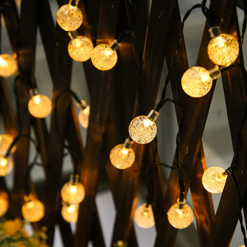 Crystal ball LED string lights with solar power, ideal for outdoor decor, gardens, and festive trees.